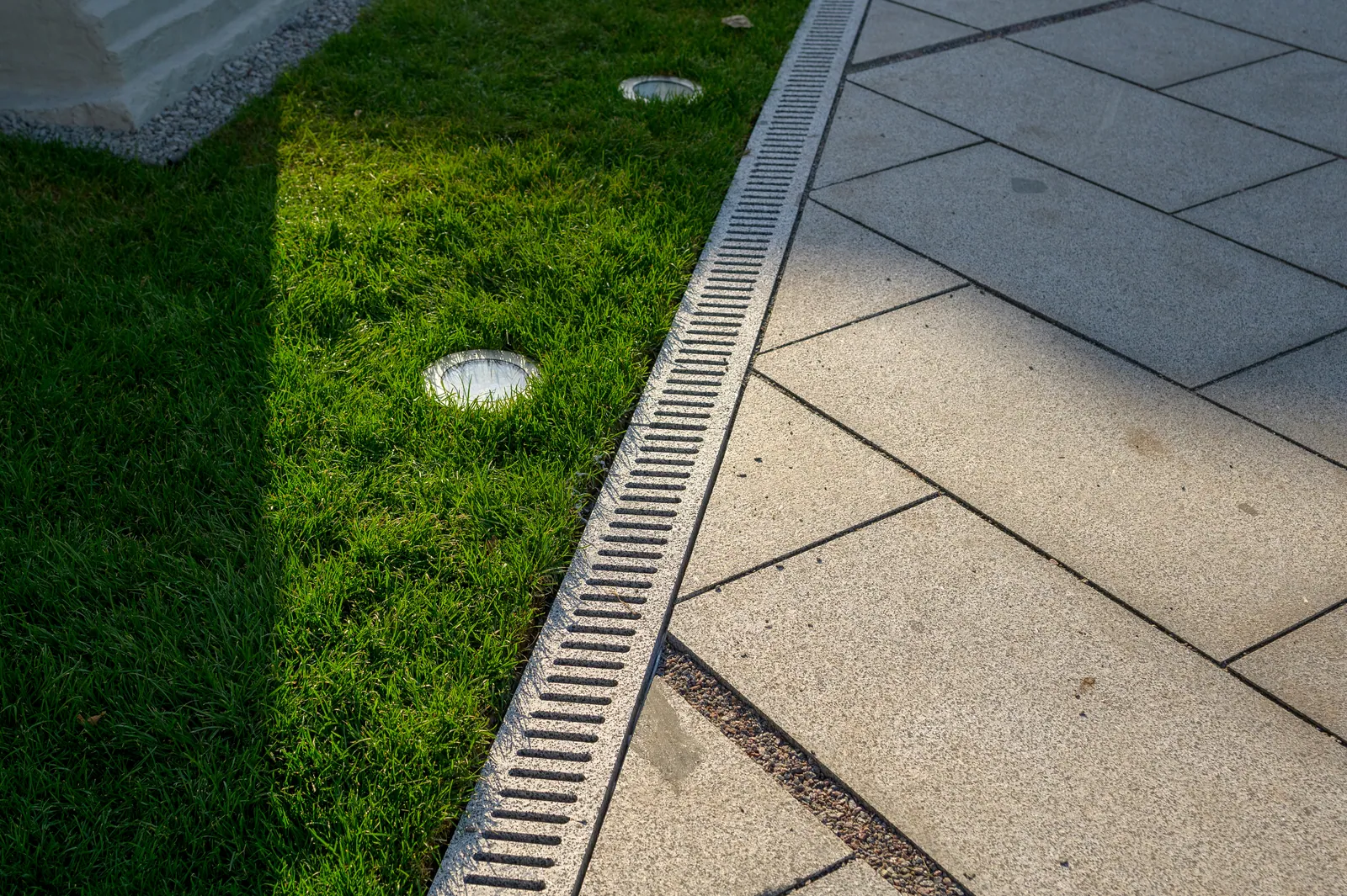 Slot drain set along the edge of a lawn to carry rainwater away in Baton Rouge, LA
